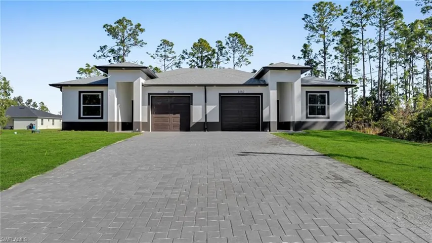 Prairie-style house with a garage, stucco siding, and a front yard