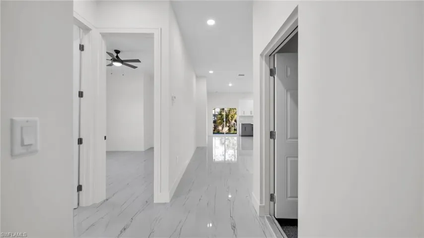 Hall featuring recessed lighting and light marble finish flooring