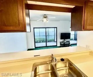Kitchen featuring brown cabinetry, ceiling fan, and light countertops