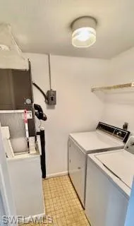 Washroom featuring washing machine and clothes dryer and light floors