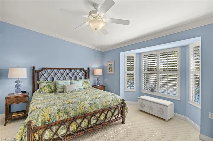 Luxurious carpeted bedroom, crown molding, wide baseboards and plantation shutters.