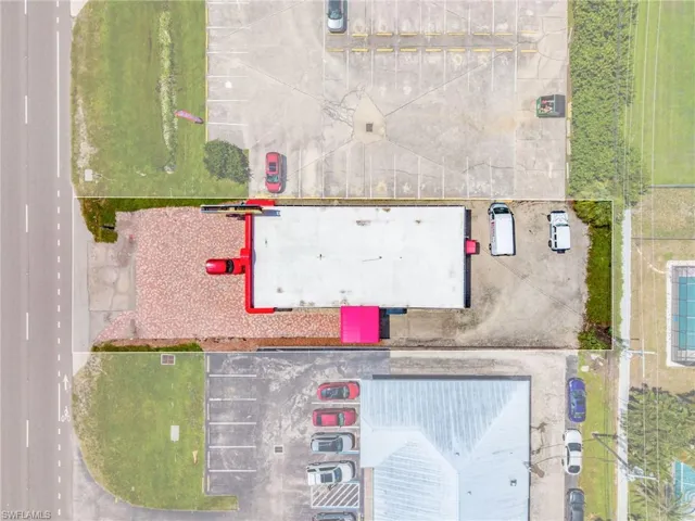 Commercial building with a flat roof, red exterior accents, and a paved front lot