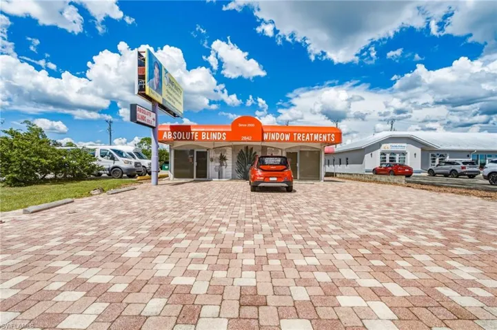 Building exterior with an orange awning, multiple storefront windows, and a prominent sign