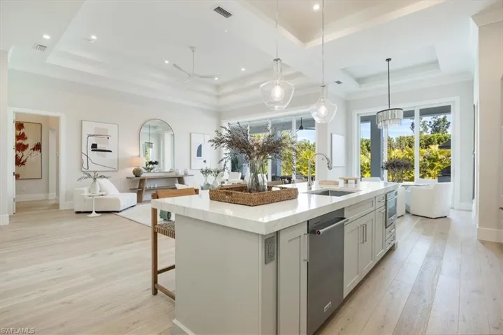 The kitchen features built-in KitchenAid french door refrigerator with freezer drawers, natural gas cooking, double ovens, and dishwasher in the island. Soft sand colored cabinetry and Pompeii quartz countertops and full backsplash complete the fresh design.
