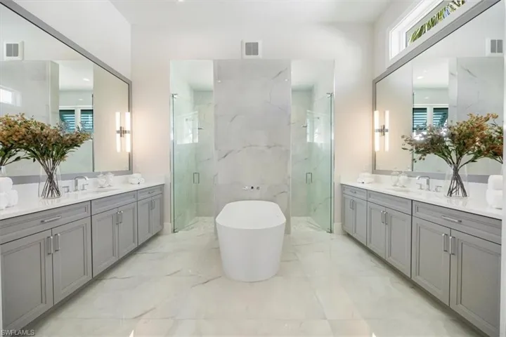 The primary bath features large scale subtle tile, a soaking tub, dual entry shower, and 8' long vanities on either side. Ample storage and natural sunlight!