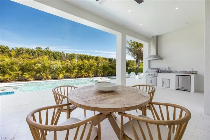 The outdoor covered living area features natural gas fireplace on one end and natural gas grill, sink, and under counter refrigerator on the other. All lanai openings have been prewired for the option of adding motorized roll-down screens after closing.