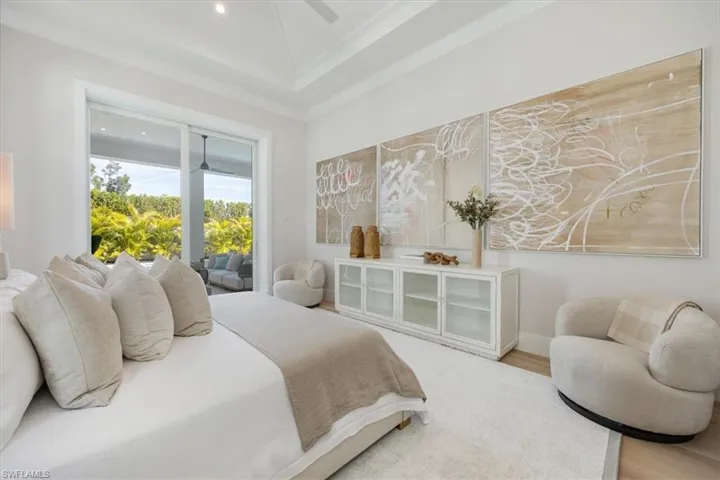 The primary bedroom overlooks the pool deck and fully landscaped backyard with privacy wall along the back.