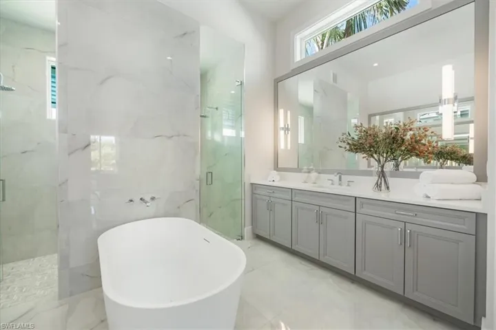 The primary bath features large scale subtle tile, a soaking tub, dual entry shower, and 8' long vanities on either side. Ample storage and natural sunlight!