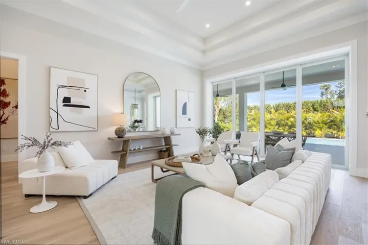 The open concept main living area features white oak flooring, 12-14' ceilings over the foyer, open chef's kitchen and wet bar, great room, and dining area.