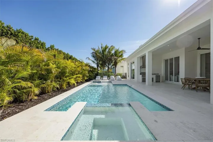 The salt swimming pool features a flush spa and sun shelf with umbrella holder and bubbler.