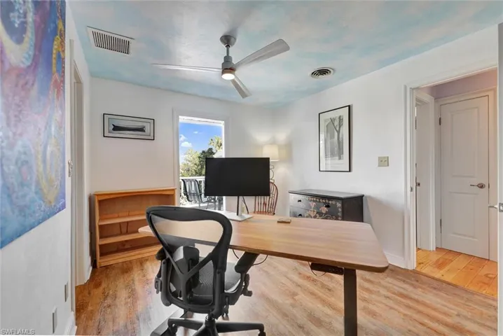 Office space with light wood-style floors and ceiling fan