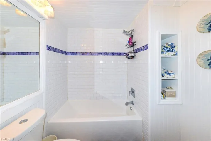 Bright kitchen featuring white cabinetry, wood-finish countertops, stainless steel appliances, and tile flooring