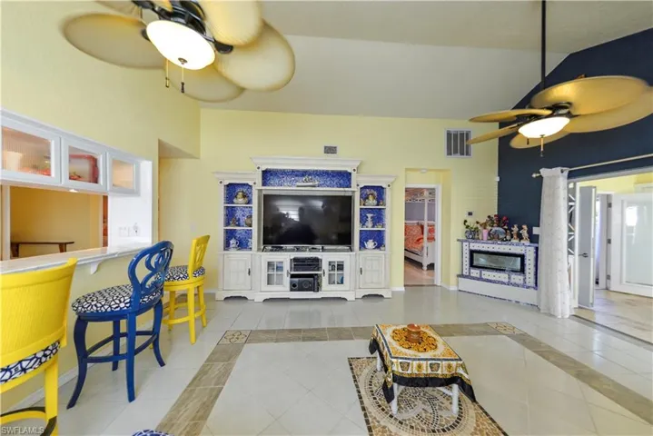 Recessed ceiling lighting, a ceiling fan, and light-tone tile flooring