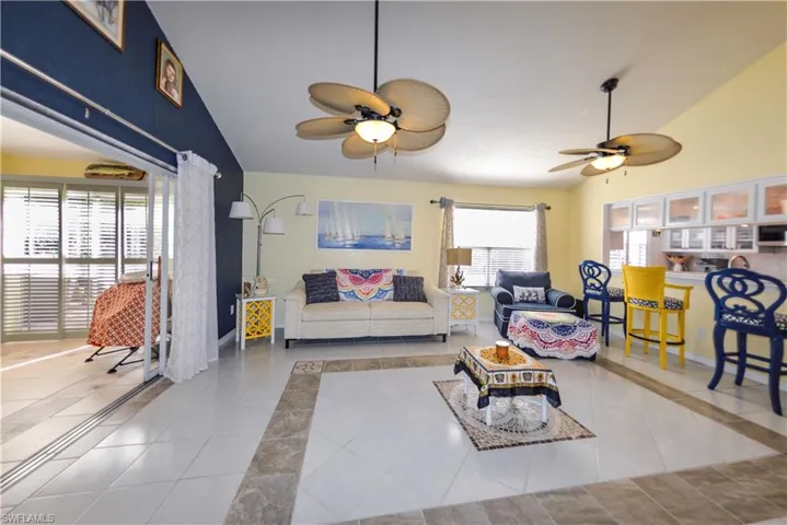 Spacious living area featuring high vaulted ceilings, multiple ceiling fans, and a built-in media center