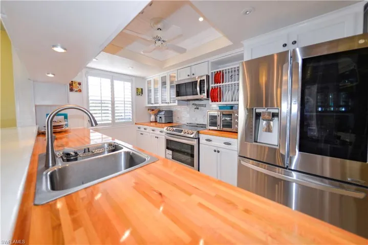 Vaulted ceilings accent a spacious living area featuring tiled flooring with a decorative inlay