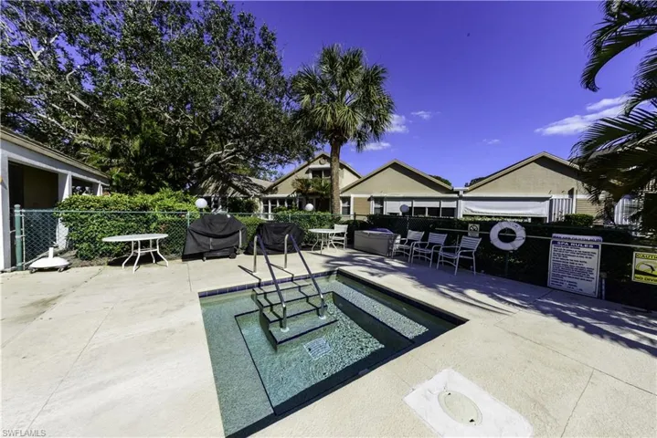 Single-story property featuring a front-facing garage with a white door, a paved driveway, and mature landscaping