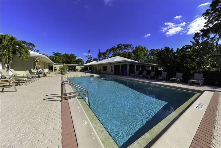 Bocce ball court with synthetic turf surface, surrounded by mature palm and pine trees