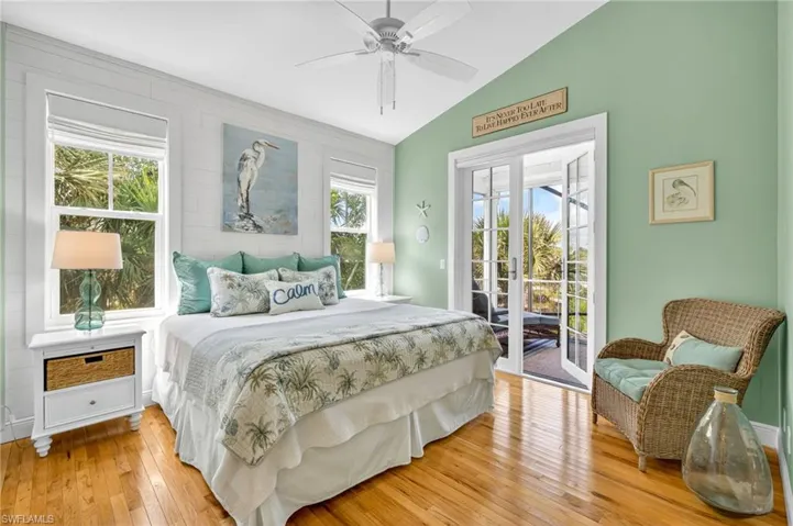 Bedroom featuring vaulted ceiling, access to outside, light wood-style floors, and a ceiling fan