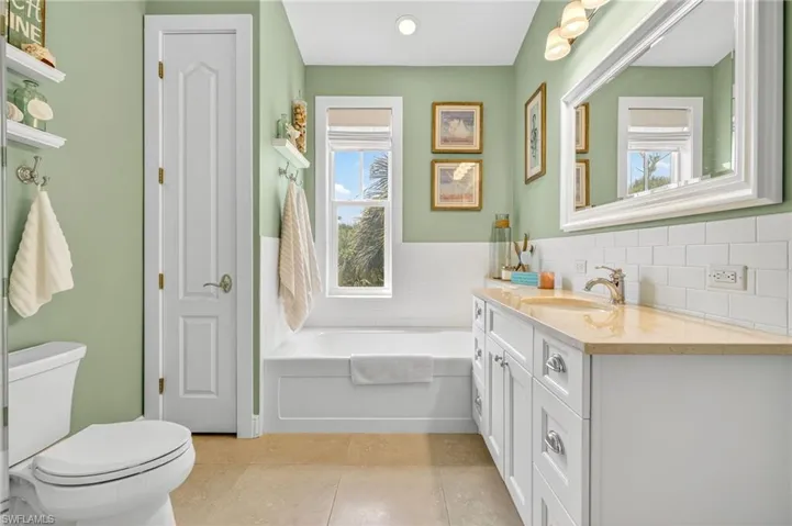 Full bath featuring vanity, a bath, and tile patterned floors
