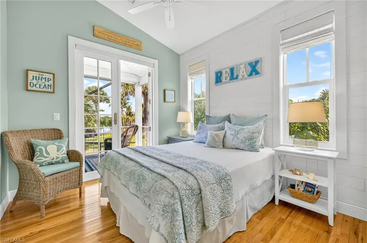 Bedroom featuring access to outside, lofted ceiling, light wood finished floors, a sunroom, and ceiling fan