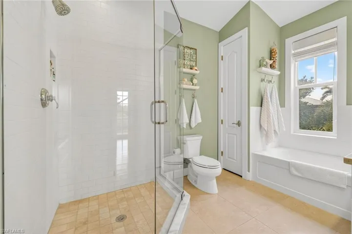Full bath with a shower stall, a bath, and tile patterned flooring