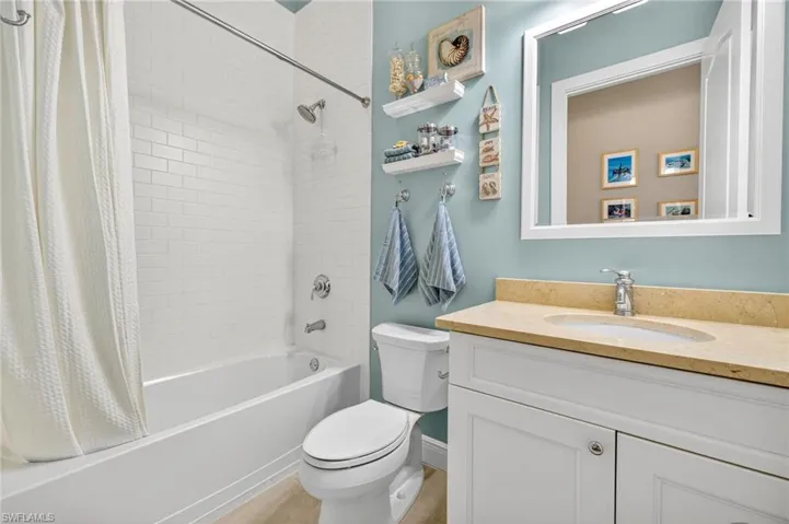 Bathroom featuring shower / bath combo with shower curtain and vanity