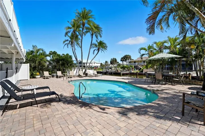 Community pool with a patio and a water view - Virtually Edited Image