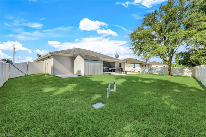 Back of house with a yard and a patio area