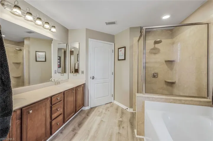 Master Bath featuring double vanity, Luxury Vinyl flooring and separate walk-in shower and tub