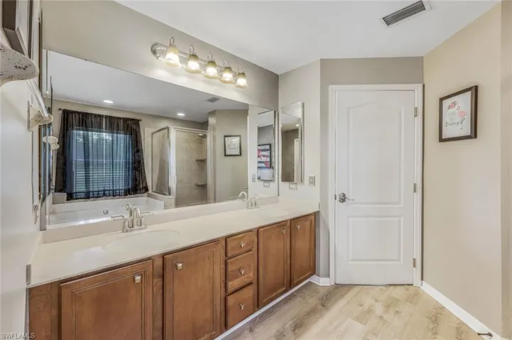 Bathroom with plus walk in shower, wood-type flooring, and double sink vanity