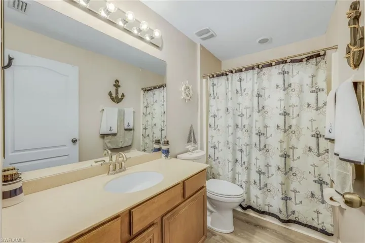 Bathroom with vanity, hardwood / wood-style flooring, and toilet
