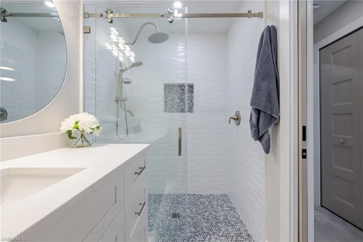 Bathroom with a shower stall and vanity