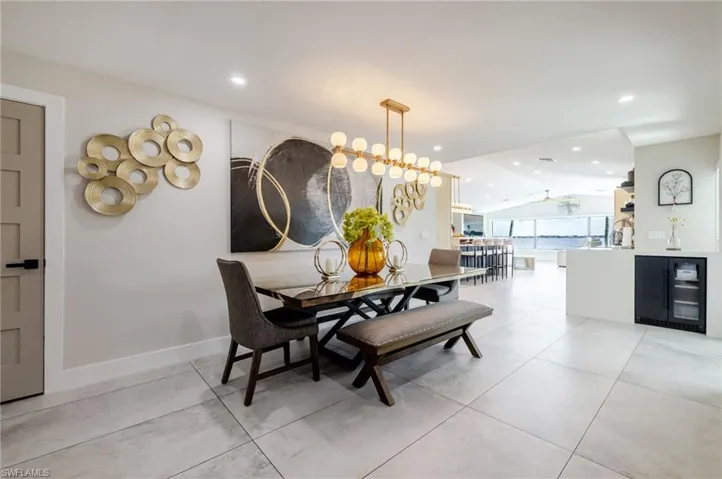 Dining room featuring beverage cooler, vaulted ceiling, recessed lighting, and light tile patterned floors