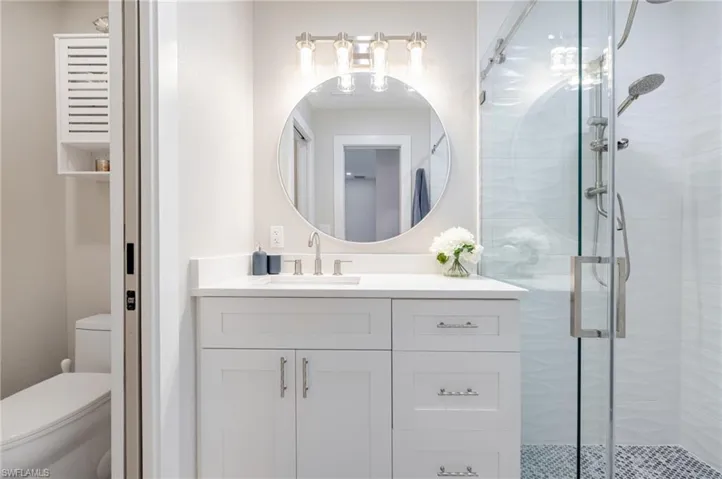 Full bath featuring a stall shower and vanity