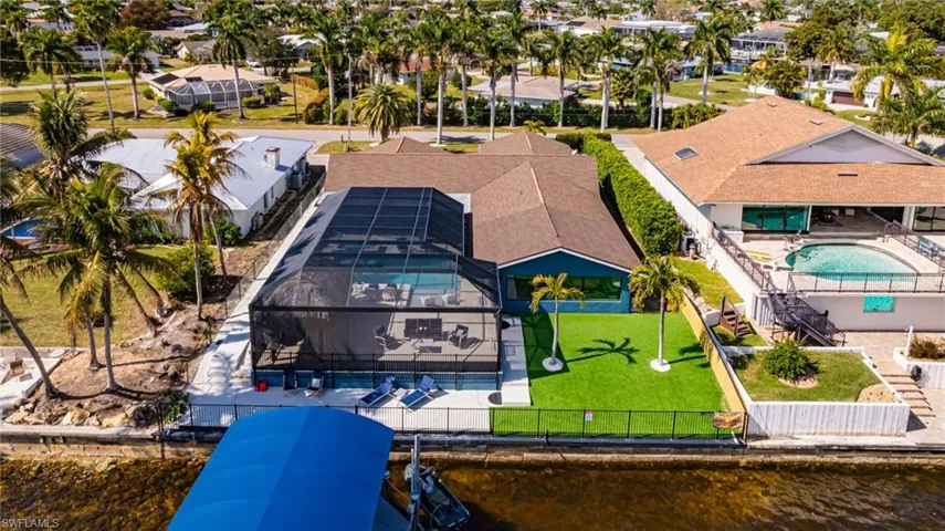 Aerial perspective of suburban area with a pool area and a large body of water