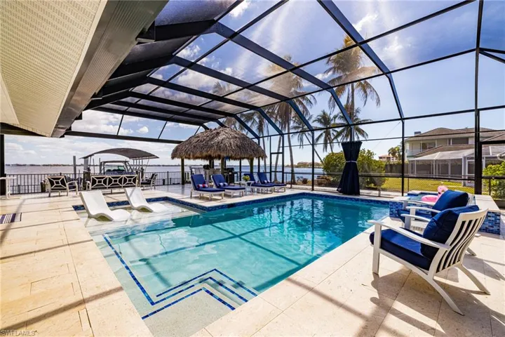 Outdoor pool with a patio area and glass enclosure