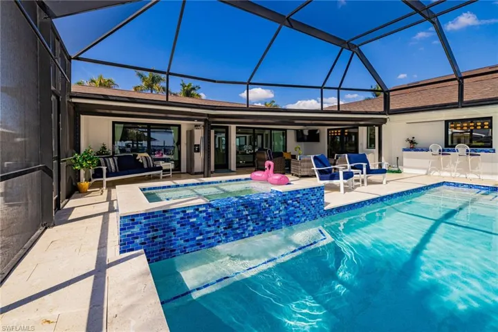 Integrated pool / hot tub with a sunroom, a patio area, and a lanai