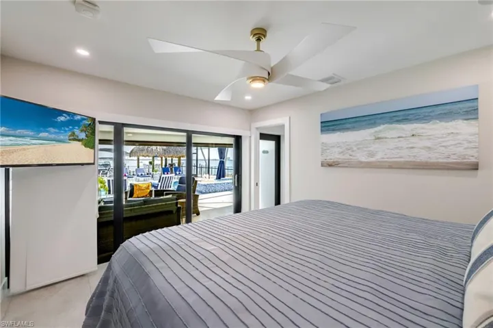 Bedroom with access to outside, a ceiling fan, recessed lighting, and a water view