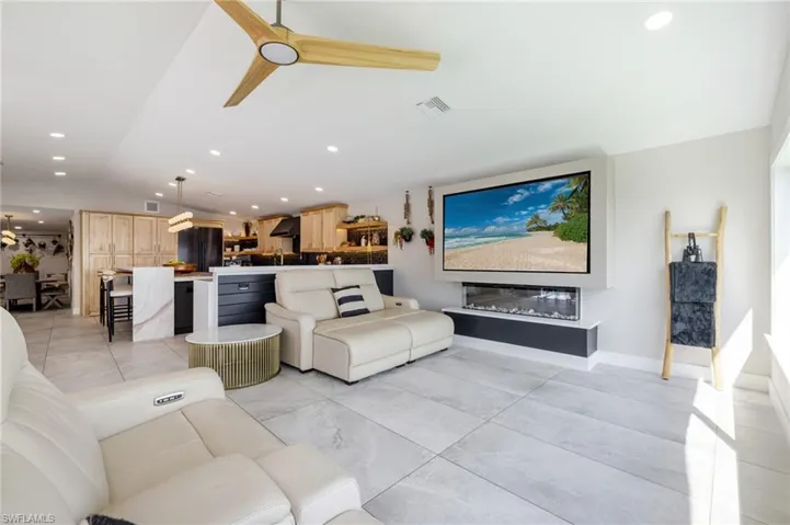 Living room with vaulted ceiling, recessed lighting, and a ceiling fan