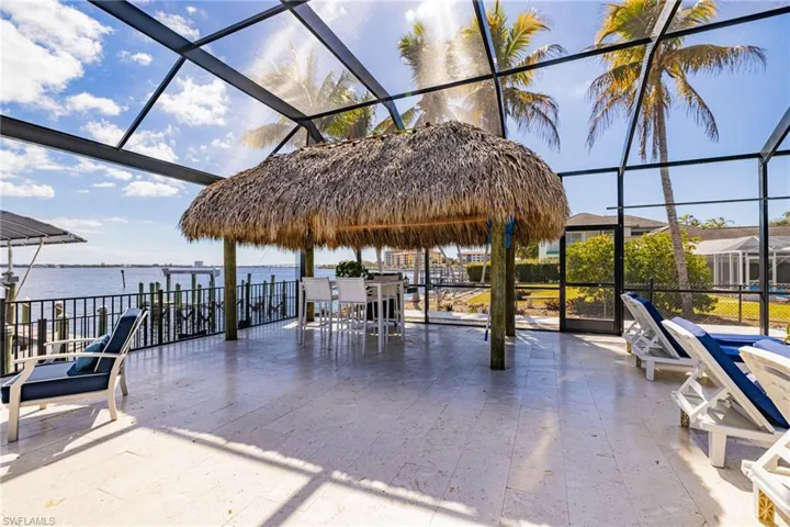 View of patio / terrace featuring glass enclosure, a sunroom, and a water view