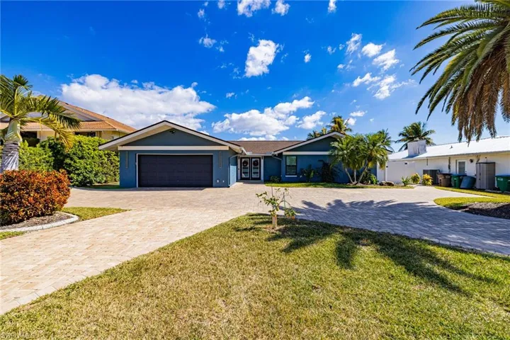 Single story home featuring decorative driveway, a front yard, an attached garage, and stucco siding
