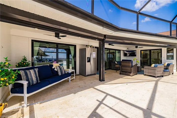 View of patio with an outdoor lounge area, ceiling fan, a sunroom, and glass enclosure
