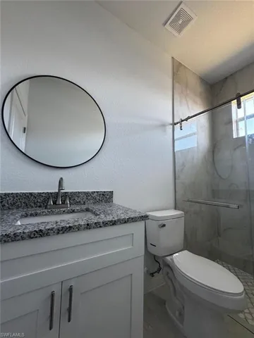 Full bath with vanity and a marble finish shower