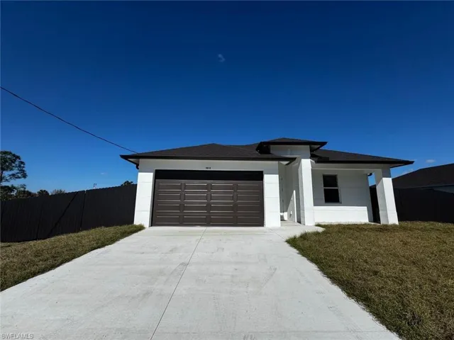 View of front of house featuring driveway, an attached garage, stucco siding, and covered porch