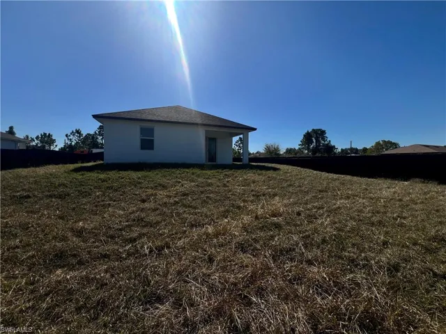 Rear view of property with stucco siding and a lawn
