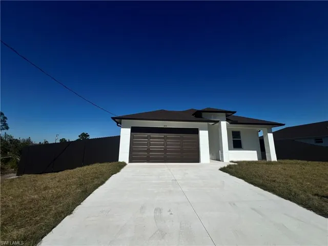 Prairie-style home with driveway, a garage, and stucco siding