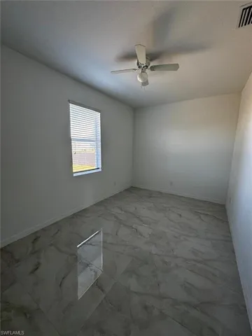Spare room with light marble finish floors and a textured ceiling
