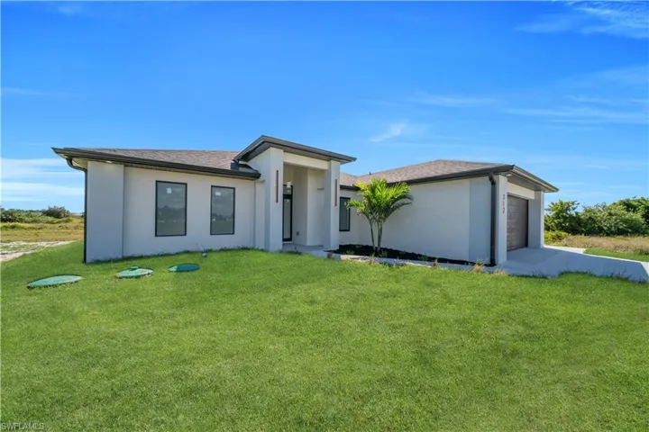 Modern stucco exterior with dark-framed windows and a complementary garage door