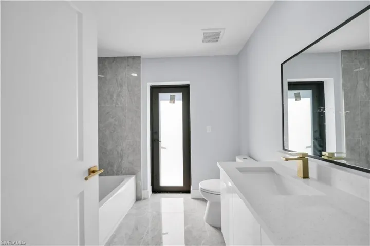 Modern bathroom featuring large format gray tile flooring and coordinating wall tile in the shower