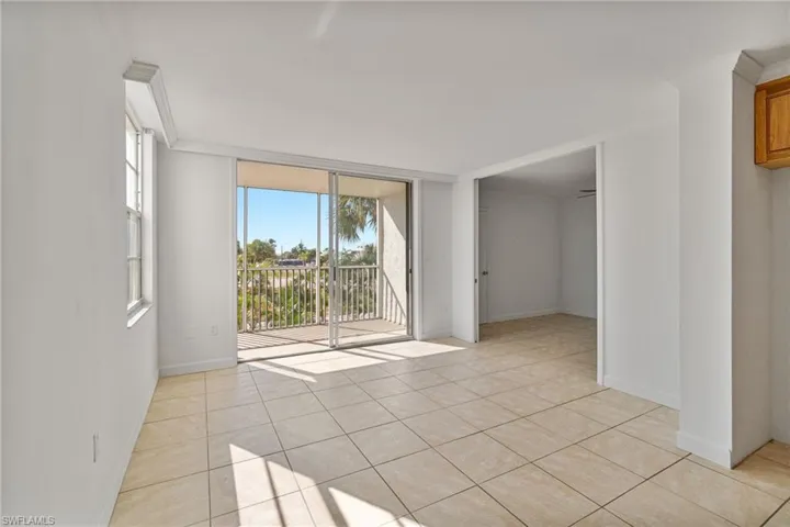 Empty room featuring expansive windows, crown molding, and light tile patterned floors